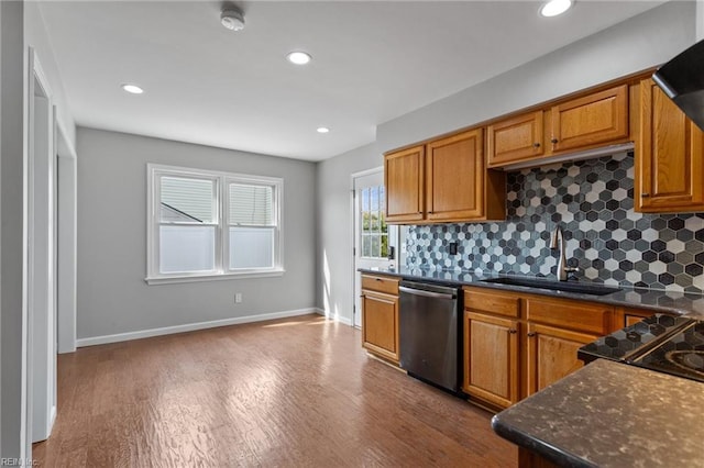 kitchen with dishwasher, dark wood-type flooring, decorative backsplash, and a sink