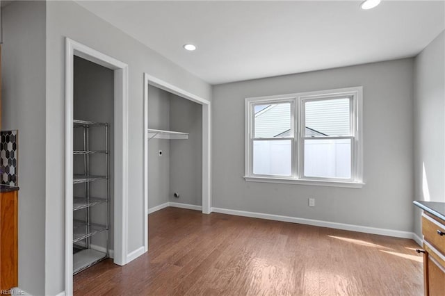 unfurnished bedroom featuring a closet, recessed lighting, baseboards, and wood finished floors