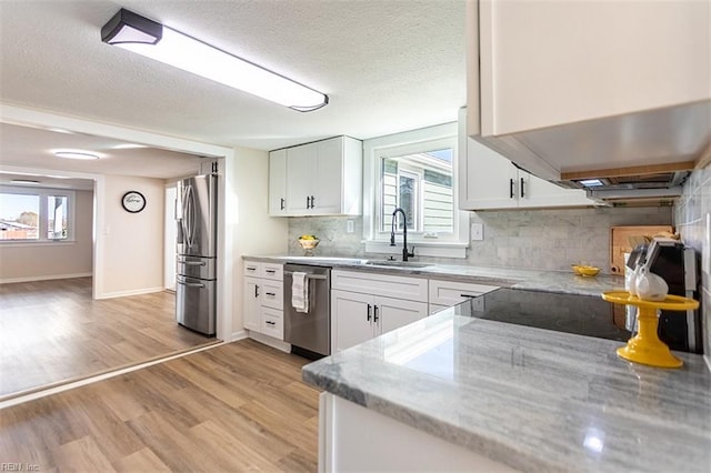 kitchen featuring a sink, light wood-style flooring, white cabinets, and stainless steel appliances
