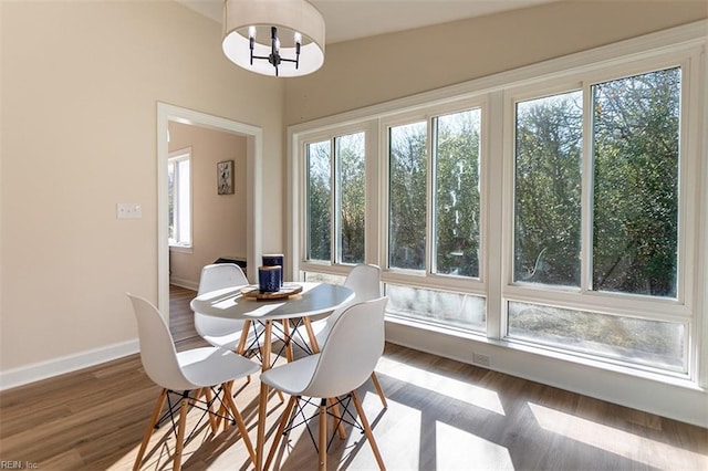 dining room featuring wood finished floors, baseboards, and a chandelier