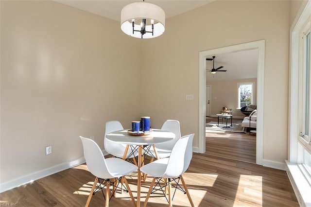 dining space with a notable chandelier, baseboards, and wood finished floors