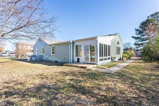 rear view of house with a lawn and a sunroom