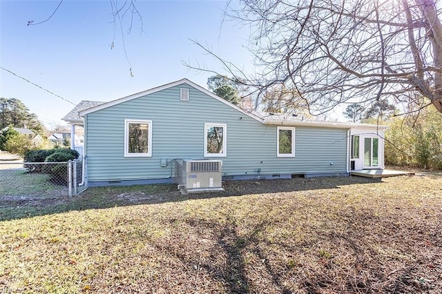 back of house with crawl space, central AC unit, a yard, and fence