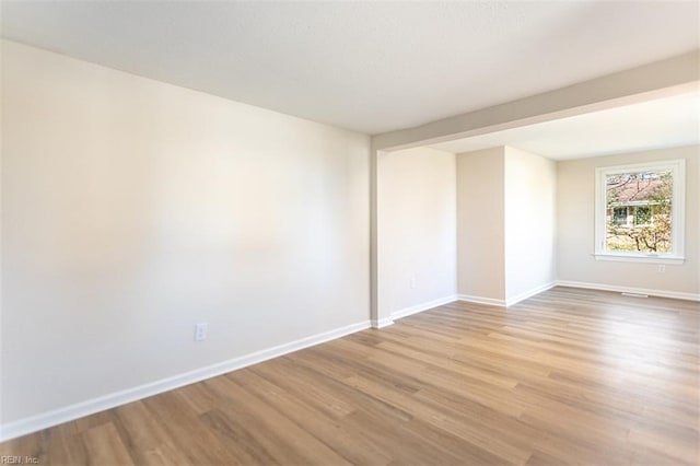 unfurnished room with light wood-style flooring and baseboards