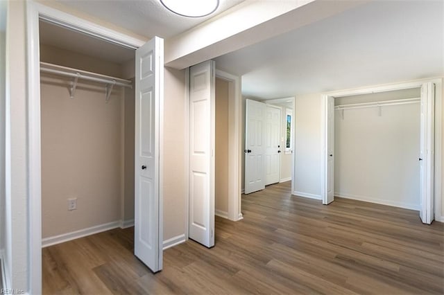 unfurnished bedroom featuring wood finished floors and baseboards