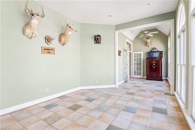 entrance foyer featuring ceiling fan, baseboards, and vaulted ceiling