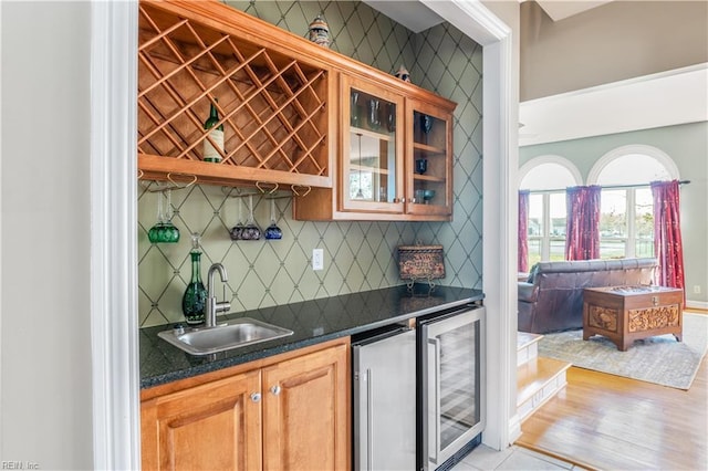 bar featuring wet bar, decorative backsplash, beverage cooler, and a sink