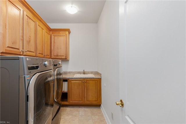 laundry area featuring independent washer and dryer, a sink, cabinet space, light tile patterned floors, and baseboards