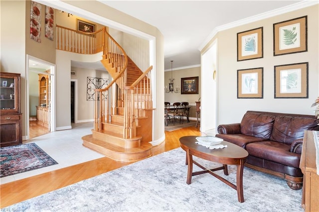 tiled living area with stairway, baseboards, and crown molding