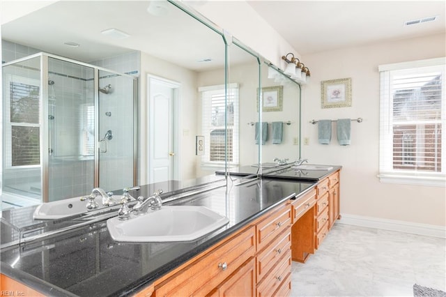 full bathroom with visible vents, baseboards, double vanity, a stall shower, and a sink