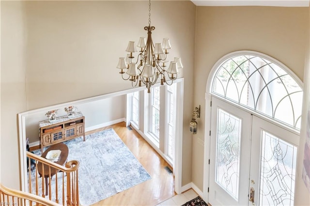 foyer with visible vents, plenty of natural light, a notable chandelier, and a high ceiling