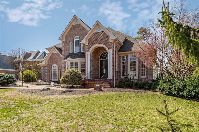 view of front of house with brick siding and a front lawn