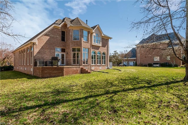 rear view of house with a yard and brick siding