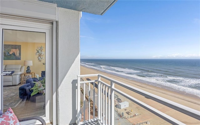 balcony featuring a beach view and a water view