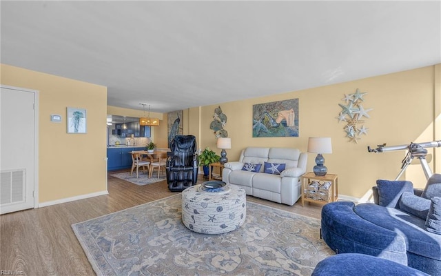 living area featuring visible vents, baseboards, and wood finished floors