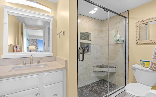 bathroom featuring toilet, a stall shower, and vanity