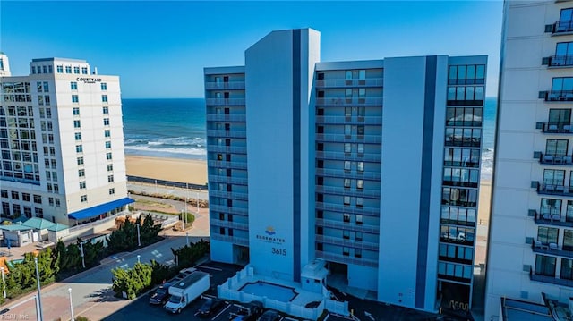 view of building exterior featuring a beach view and a water view