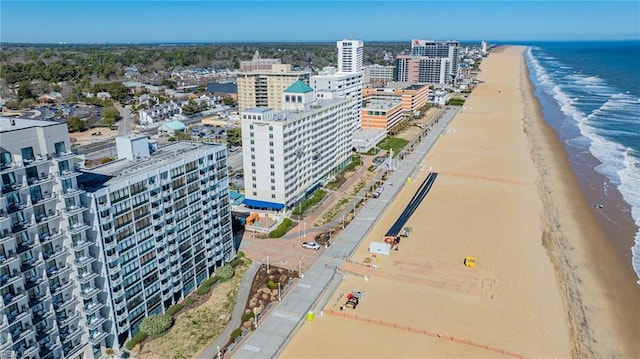 drone / aerial view featuring a city view, a view of the beach, and a water view