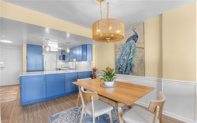 dining area featuring wood finished floors and wainscoting