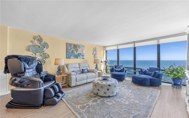 living area featuring a wall of windows, wood finished floors, and a water view