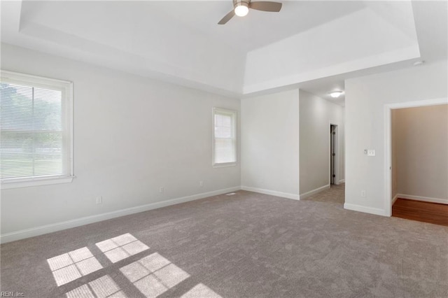 unfurnished room featuring baseboards, a raised ceiling, ceiling fan, and carpet floors