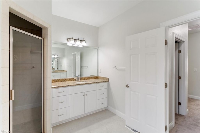 bathroom featuring baseboards, vanity, and a shower stall