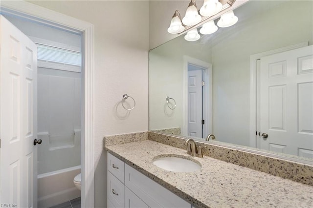 bathroom with toilet, vanity, and an inviting chandelier