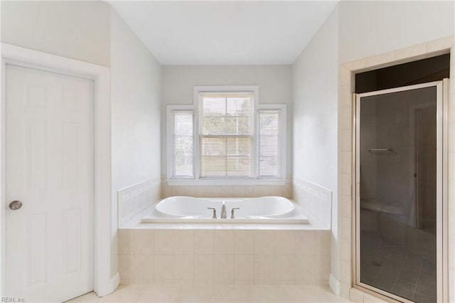 bathroom with tile patterned floors, a shower stall, and a garden tub