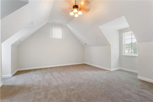 additional living space featuring baseboards, carpet, lofted ceiling, and a ceiling fan