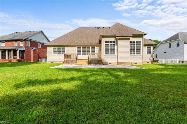 back of house featuring a lawn, a patio, fence, roof with shingles, and crawl space