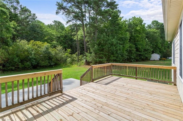 wooden deck featuring a shed, an outdoor structure, and a yard