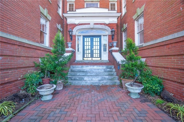 property entrance featuring brick siding and french doors