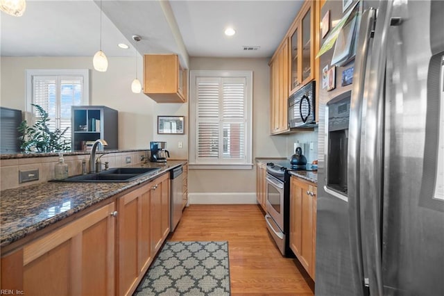 kitchen with light wood-type flooring, visible vents, a sink, tasteful backsplash, and stainless steel appliances