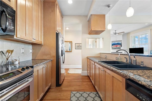 kitchen featuring a sink, backsplash, light wood finished floors, and stainless steel appliances