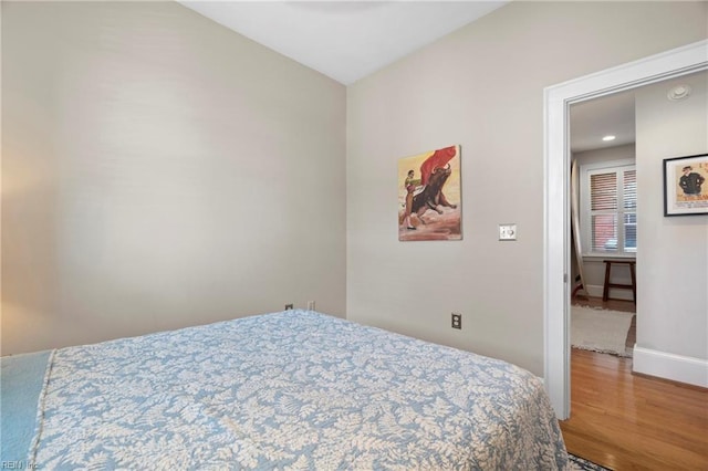 bedroom with baseboards and wood finished floors