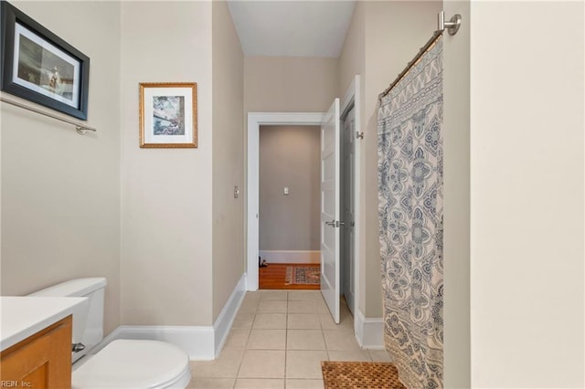 full bath featuring toilet, a shower with shower curtain, tile patterned flooring, baseboards, and vanity