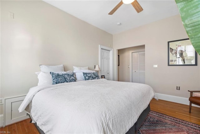 bedroom featuring baseboards, wood finished floors, and a ceiling fan