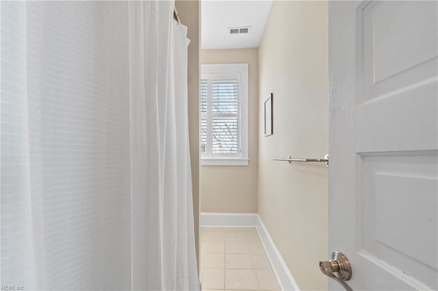 bathroom featuring tile patterned floors, visible vents, and baseboards