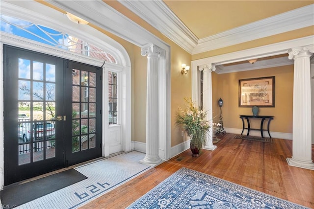 entrance foyer with hardwood / wood-style floors, baseboards, decorative columns, ornamental molding, and french doors