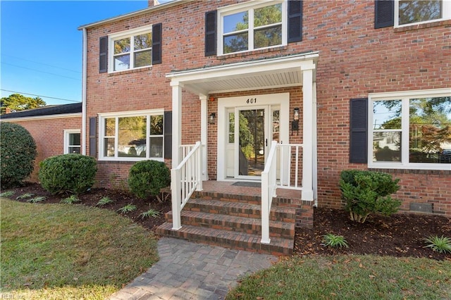 doorway to property featuring brick siding