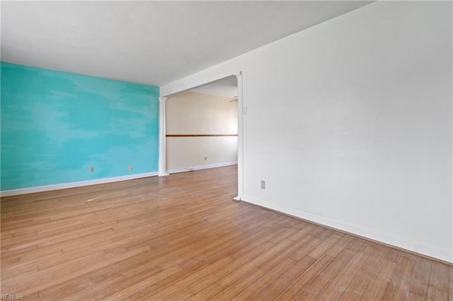 spare room featuring wood finished floors and baseboards