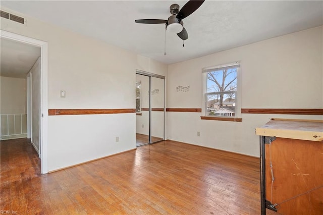 interior space featuring visible vents, ceiling fan, and wood-type flooring