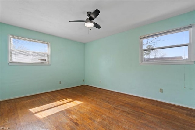 empty room with hardwood / wood-style floors, a healthy amount of sunlight, baseboards, and ceiling fan