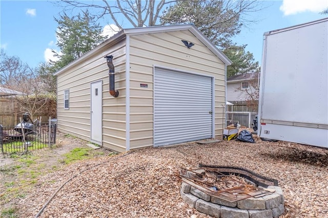 detached garage featuring fence