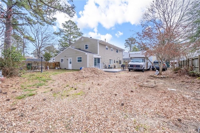 rear view of property featuring a patio area and fence