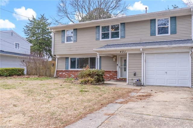 view of front facade with driveway, fence, a front yard, a garage, and brick siding