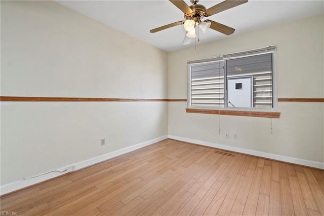 empty room with ceiling fan, baseboards, and wood finished floors