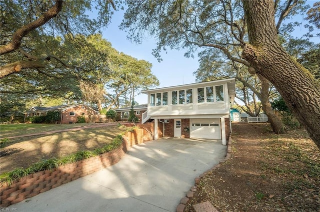 view of front of home with brick siding, an attached garage, and driveway