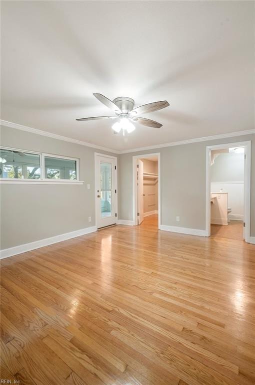 empty room with crown molding, baseboards, light wood finished floors, and ceiling fan