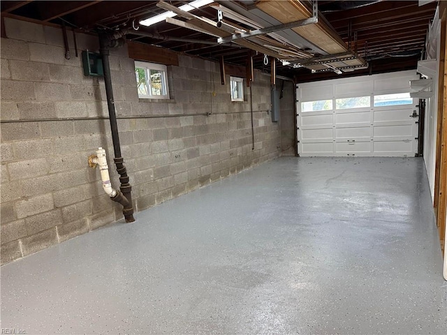 garage featuring electric panel and concrete block wall